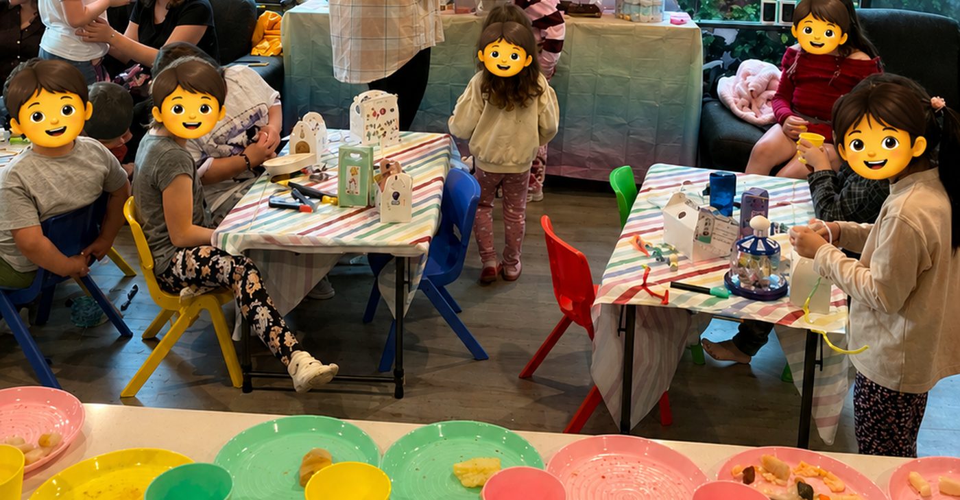 Children seated on yellow, blue, red and green kids chairs at folding tables set to kids height during a birthday party